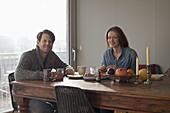 Couple having breakfast at dining table, portrait
