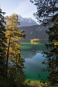 Kayaker paddling on lake Eibsee below Zugspitze, Grainau, Bavaria, Germany