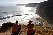 Junges Paar betrachtet den Aussicht, Surferstrand bei Sagres, Algarve, Portugal
