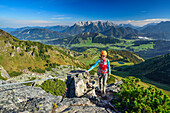 Woman ascending fixed rope route, Loferer Steinberge range in background, fixed rope route Henne, Henne, Kitzbuehel range, Tyrol, Austria