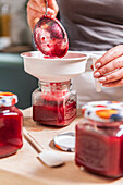 Person filling jam into a glass, Hamburg, Germany