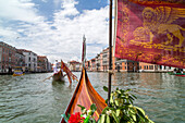 Blick über Gondelspitze und rote Flagge der Serenissima mit dem Löwen von San Marco, Venedig, Italien