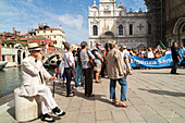 Protestors gather in front of city hospital, demonstration against cuts in health care, man in white suit with hat observes, Campi Santi Giovanni e Paolo, Venice, Italy