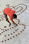 India, Uttar Pradesh, Varanasi, Dev Deepawali festival, Hindu devotee setting earthen lamps.