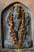 India, Uttar Pradesh, Varanasi, Lalita Ghat, Nepali temple (also called Kathwala temple), Garlanded bas relief of Kal Bhairava.