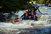 Group of people white water rafting on the Trwyeryn river, National White Water Centre, near Bala Gwynedd north wales UK