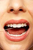 Close Up Of Woman Flossing Teeth