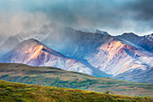 'Morning light falls on the colourful mountain hillsides of Polychrome mountains in Denali National Park; Alaska, United States of America'