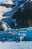 Sea Kayakers along the tidewater face of Harriman glacier, Prince William Sound, southcentral, Alaska.