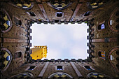 'Low angle view to the sky inside the four walls of the Torre del Mangia; Siena, Tuscany, Italy'