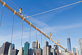 Men painting a suspension cable of the Brooklyn Bridge, New York City, New York, United States