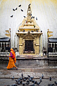 A woman in a sari circumambulates the Swayambu Temple in Kathmandu, Nepal