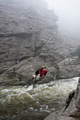 A climber crosses a swollen creek on a tyrolean traverse. The tyrolean traverse allows adventurers to cross rivers and chasms without bridges.