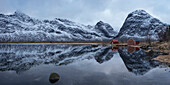 Boat sheds and mountains reflection on Selfjord in winter, Moskenes??y, Lofoten Islands, Norway