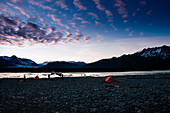 Campers set up camp across from Bear Lake and Bear Glacier at sunset in Kenai Fjords National Park, Alaska.