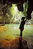 Young woman standing by a hidden lagoon in the jungle above Railay beach