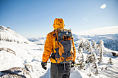 Climber wearing a backpack in a winter landscape in the Coquihalla Recreation Area of British Columbia, Canada.