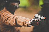A man points an airsoft pistol.