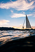 The small yacht Freshwater Cowboy is sailing on Lake Tahoe at sunset.