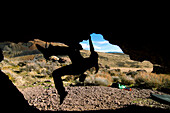 A silouette of a woman bouldering.