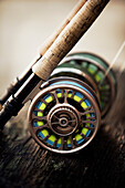 a short focus shot of fly reel resting on wooden plank
