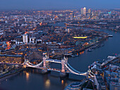 Aerial photo showing Tower Bridge, River Thames and Canary Wharf at dusk, London, England, United Kingdom, Europe