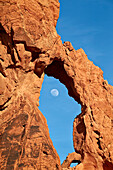 Near-full moon rising through an arch, Valley of Fire State Park, Nevada, United States of America, North America