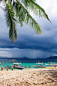 Outrigger boats before a strom anchoring on a sandy beach  in  the Bacuit archipelago, Palawan, Philippines, Southeast Asia, Asia