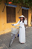 Woman wearing Ao Dai dress with bicycle, Hoi An, Quang Nam, Vietnam, Indochina, Southeast Asia, Asia