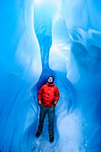 Man standing in an ice cave, Fox Glacier, Westland Tai Poutini National Park, South Island, New Zealand, Pacific