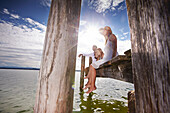 Familie auf einem Steg am Starnberger See, Oberbayern, Bayern, Deutschland