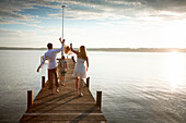 Familie auf einem Steg am Starnberger See, Oberbayern, Bayern, Deutschland