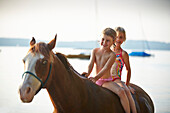 Two girls on horse back at lake Starnberg, Upper Bavaria, Bavaria, Germany