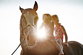 Two girls on horse back at lake Starnberg, Upper Bavaria, Bavaria, Germany