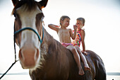 Zwei Mädchen auf einem Pferd am Starnberger See, Oberbayern, Bayern, Deutschland