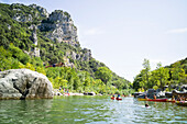 Canoing on river Herault, man jumping from a rock into water, Herault gorge, Saint-Bauzille-de-Putois, Ganges, Herault, Languedoc-Roussillon, France