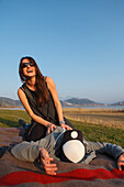 Young couple on a blanket near lake Grosser Alpsee, Immenstadt, Bavaria, Germany