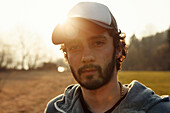 Young man looking at camera, Grosser Alpsee, Immenstadt, Bavaria, Germany