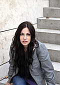 Junge Frau sitzt auf einer Treppe, München, Bayern, Deutschland