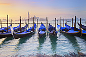 Gondolas moored on Grand Canal and Church of San Giorgio Maggiore beyond at sunrise, near Piazza San Marco, Venice, Veneto, Italy, Europe.