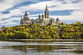 Parliament Hill with fall foliage color and the Ottawa River from Hull, Quebec, Canada.