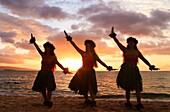 Three hula dancers at sunset at Palauea, Maui, Hawaii