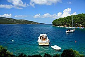 A boat and a yacht with tourists in a small bay in Osor village on Cres Island, Croatia