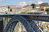 Pedestrians and electric trolley car cross the Dom Luis I Bridge over Douro river, Porto, Douro Litoral Province, Portugal, Europe.