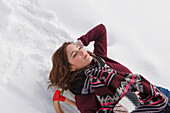 Young woman lying on a sled, Spitzingsee, Upper Bavaria, Germany