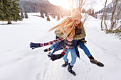 Young woman giving friend a piggyback ride, Spitzingsee, Upper Bavaria, Germany