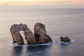 Dramatic arch in rocks Cantabria coast at sunset