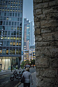 Frau spaziert durch Hochhaus Schluchten der Bankgebäude in London's Finanzdistrikt, London, England, Vereinigtes Königreich, Europa
