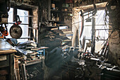 warm light shining through the window of a chaotic blacksmiths workshop, Vellberg, Schwaebisch Hall, Baden-Wuerttemberg, Germany