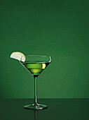 Cocktail Appletini vor grünem Hintergrund, Cocktail, Drink